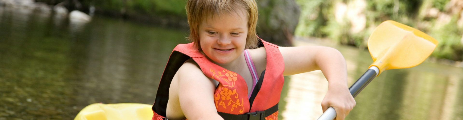 Young girl enjoying kayaking at a lake